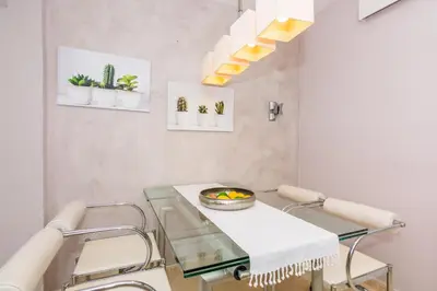 a dining room with a glass table and plants on the wall at HomeHolidaysRentals Amaral in Pineda de Mar