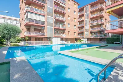 a swimming pool in front of a apartment building at HomeHolidaysRentals Amaral in Pineda de Mar