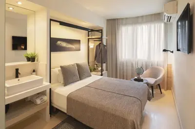 a bedroom with a bed and a sink and a tub at Hotel Denit Barcelona in Barcelona