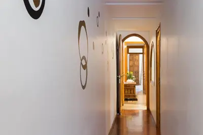 a hallway with a white wall and an arched doorway at Casa Cosi Mallorca I in Barcelona
