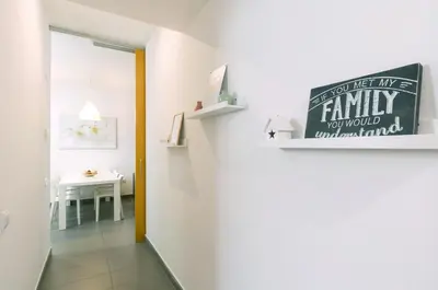a hallway with a white room with a sign on the wall at Apartamentos Cornellalux 2 in Cornellà de Llobregat