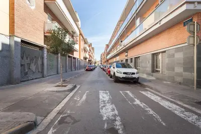 an empty street with cars parked on the side at Apartamentos Cornellalux 2 in Cornellà de Llobregat
