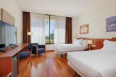 a hotel room with a bed and a desk at Sercotel Arrahona Sabadell in Sabadell