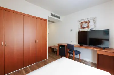 a hotel room with a bed and a television at Sercotel Arrahona Sabadell in Sabadell