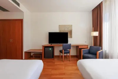 a hotel room with a desk and a tv at Sercotel Arrahona Sabadell in Sabadell