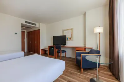 a hotel room with a bed and a table and chairs at Sercotel Arrahona Sabadell in Sabadell