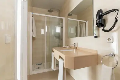 a bathroom with a sink and a shower at Aparthotel Solifemar in Castelldefels