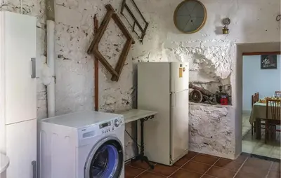 a kitchen with a washing machine and a refrigerator at Lovely Apartment In Pineda De Mar in Pineda de Mar