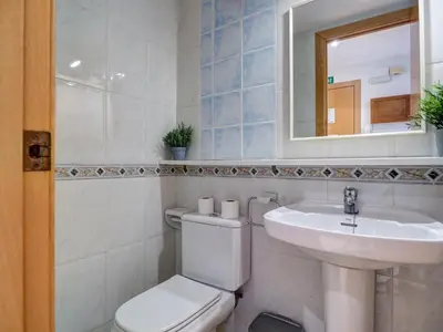 a bathroom with a toilet and a sink and a mirror at Parellades Apartment by Hello Homes Sitges in Sitges