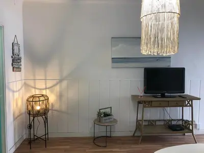 a living room with a television and a table with a lamp at Vilasardemarlux1 in Vilassar de Mar
