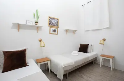 two beds in a room with white walls at CasaNova Guest House in Barcelona