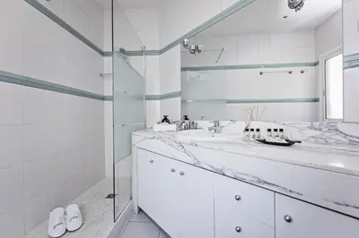 a bathroom with two sinks and a glass shower at Sweett - Pedrera Department 24 in Barcelona