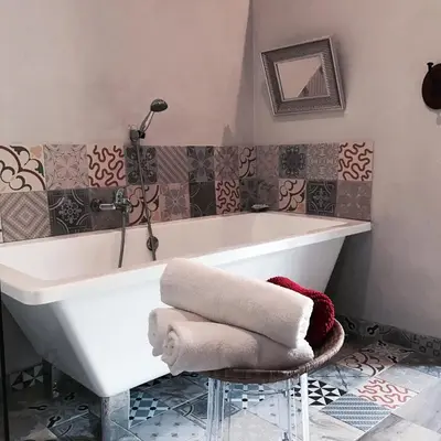 a white bath tub in a bathroom with tiles at Hostal Sant Roc in Montseny