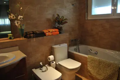 a bathroom with a toilet and a sink and a tub at Can Vinyals Holiday Home in Castellar