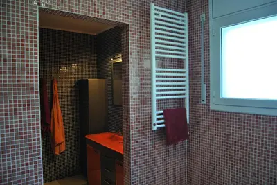 a bathroom with a red tiled walls and a window at Can Vinyals Holiday Home in Castellar