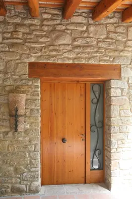 a wooden door of a stone building at Entre Roures in Moià