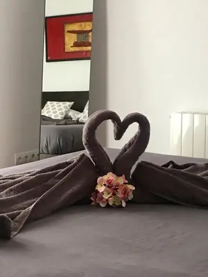 two towels in the shape of a heart on a bed at Vilamarlux I in Vilassar de Mar