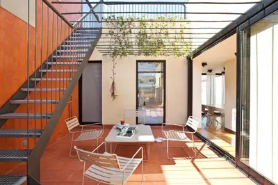 a room with a table and chairs and a staircase at DestinationBCN Urgell Apartment in Barcelona