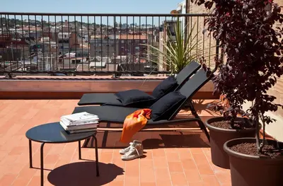 a bird sitting on a chair on a balcony at DestinationBCN Urgell Apartment in Barcelona