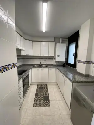 an empty kitchen with white cabinets and a sink at Vivalidays Yolanda in Calella