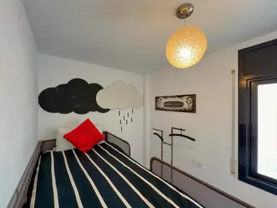 a bedroom with a black and white bed with a red pillow at Vivalidays Yolanda in Calella