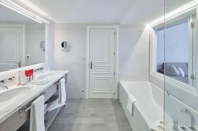 a white bathroom with two sinks and a bath tub at Hotel Casa Vilella 4* Sup in Sitges