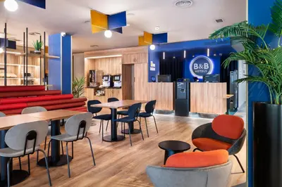 a restaurant with tables and chairs and a couch at B&B HOTEL Barcelona Rubí in Rubí