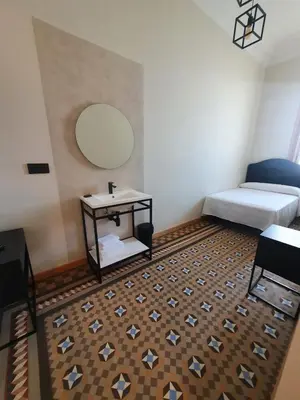 a room with a bed and a table with a mirror at Hostal Lausanne in Barcelona