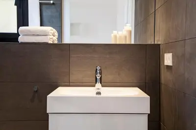 a bathroom with a white sink and a mirror at DestinationBCN Marimon Apartment in Barcelona