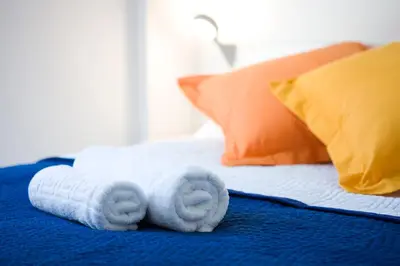 a pile of towels on a bed with pillows at Live & Dream in Barcelona