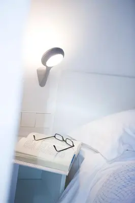 a table with a lamp and glasses on a bed at Live & Dream in Barcelona