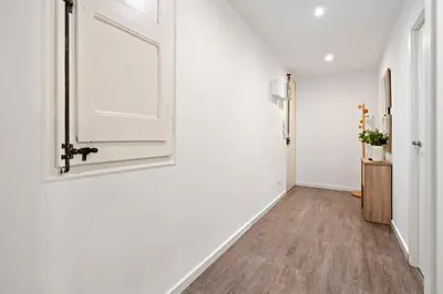 a hallway with white walls and a door at Camp Nou Apartment in Hospitalet de Llobregat