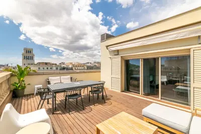 a patio with a table and chairs on a deck at Unique Rentals - Placa Catalunya Central Apartments in Barcelona