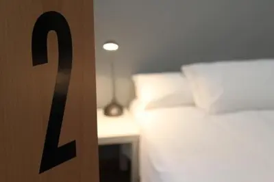 a bedroom with a bed and a table with a lamp at Hostal Nitzs Bcn in Barcelona