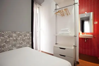 a bedroom with a white bed and a sink at Hostal Nitzs Bcn in Barcelona
