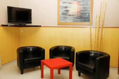 two chairs and a red table in a waiting room at Hostal Nuevo Colon in Barcelona