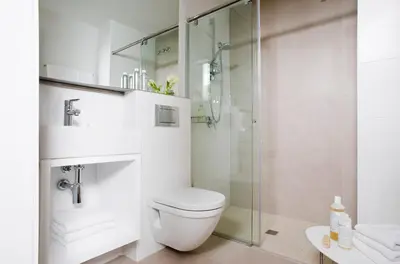 a bathroom with a toilet and a glass shower at Eric Vökel Boutique Apartments - BCN Suites in Barcelona