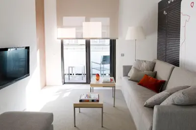 a living room with a couch and a tv at Eric Vökel Boutique Apartments - BCN Suites in Barcelona