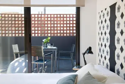 a bedroom with a table and chairs and a window at Eric Vökel Boutique Apartments - BCN Suites in Barcelona
