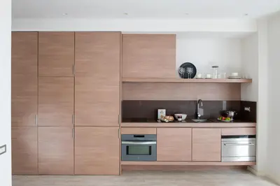 a kitchen with wooden cabinets and a stove at Eric Vökel Boutique Apartments - BCN Suites in Barcelona