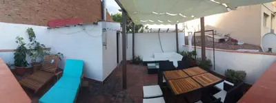an outdoor patio with tables and chairs and an umbrella at LG Big Flat Barcelona in Badalona