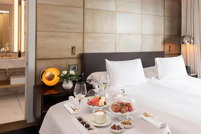 a hotel room with a bed with a tray of food at Almanac Barcelona in Barcelona