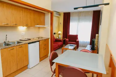 a kitchen and living room with a table and chairs at Aparthotel Bertrán in Barcelona