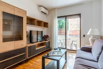 a living room with a couch and a tv at Aparthotel Bertrán in Barcelona