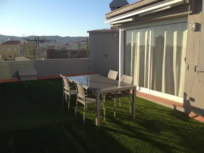 a table and chairs on the roof of a house at Fisa Rentals Shopping in Barcelona