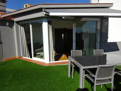 a patio with a table and chairs on the grass at Fisa Rentals Shopping in Barcelona