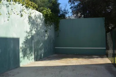 a green fence next to a white wall at Villa Med A 2 kilometros andando de la playa, del puerto de Aguadoç y a 4 del centro de Sitges Muy Soleada todo el dia Capacidad superior a 16 personas NO REQUIERE COCHE in Sitges