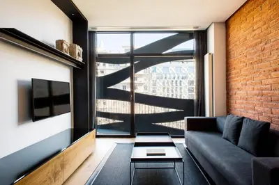 a living room with a couch and a large window at Suites Avenue in Barcelona