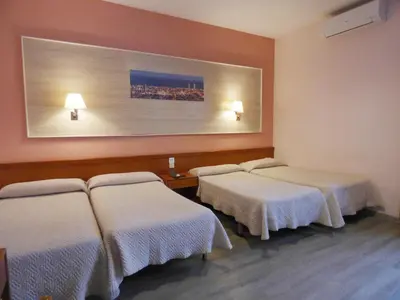 a room with three beds and a picture on the wall at Cuatro Naciones in Barcelona