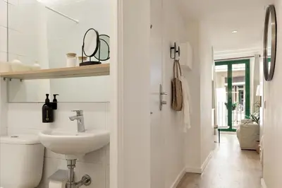 a white bathroom with a sink and a toilet at Ola Living Vidreria in Barcelona